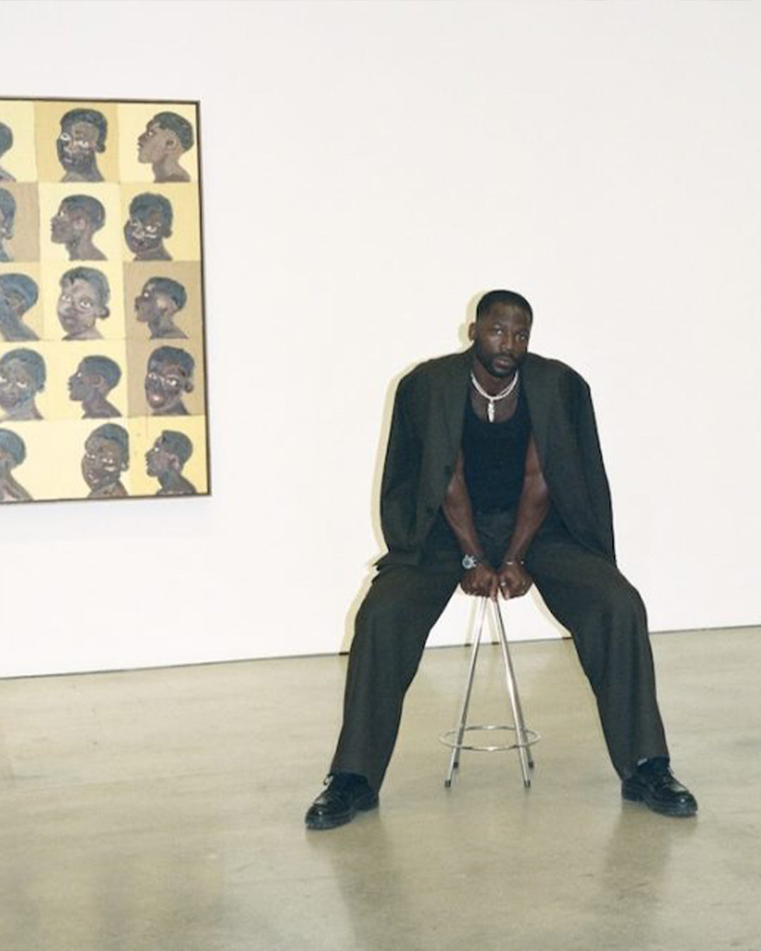 Ludovic Nkoth in front of his painting in an art gallery.